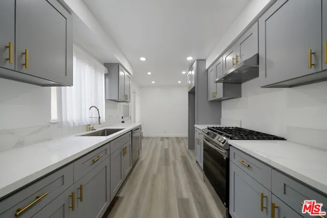 a kitchen with a sink stove and cabinets
