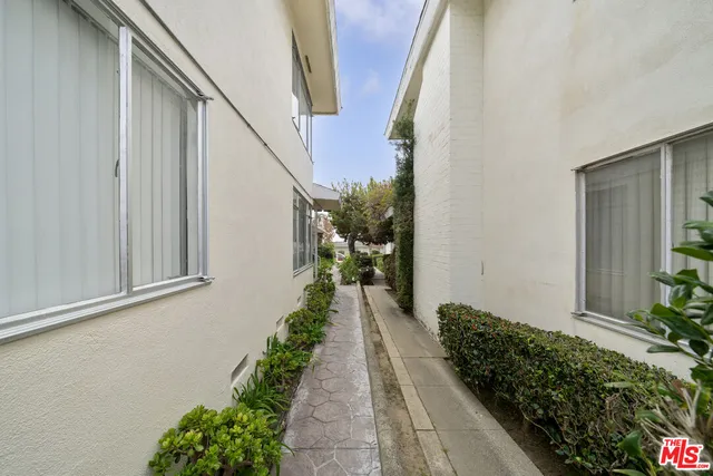 a view of a pathway of a house with flower plants