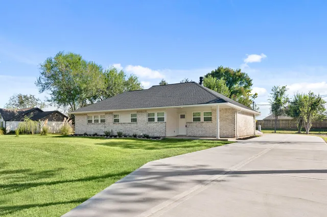 a view of a house with a big yard and large trees