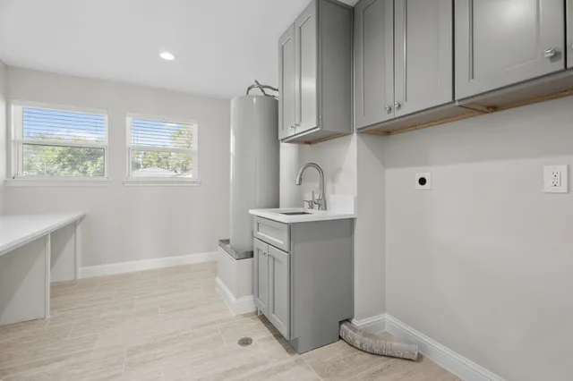 a room with a sink cabinets and utility room