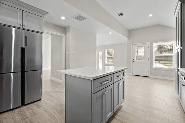 a kitchen with stainless steel appliances granite countertop a refrigerator a stove and a refrigerator