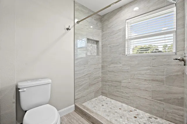 a bathroom with a toilet and a shower