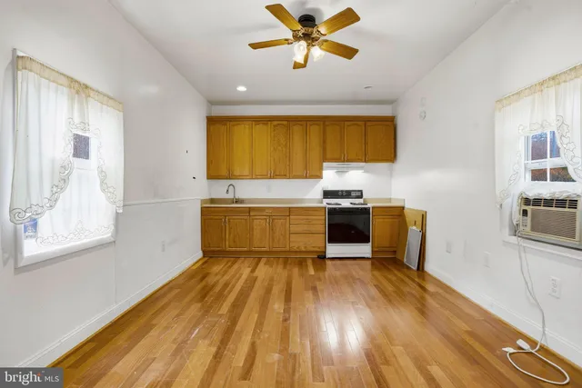 a kitchen with kitchen island wooden floors appliances and cabinets