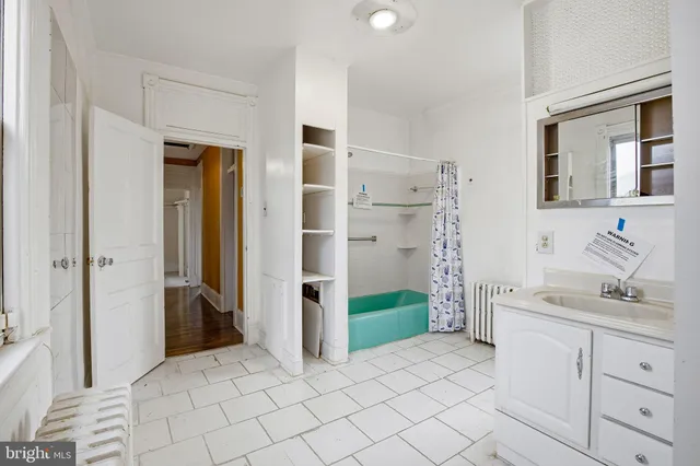 a spacious bathroom with a mirror sink and shower