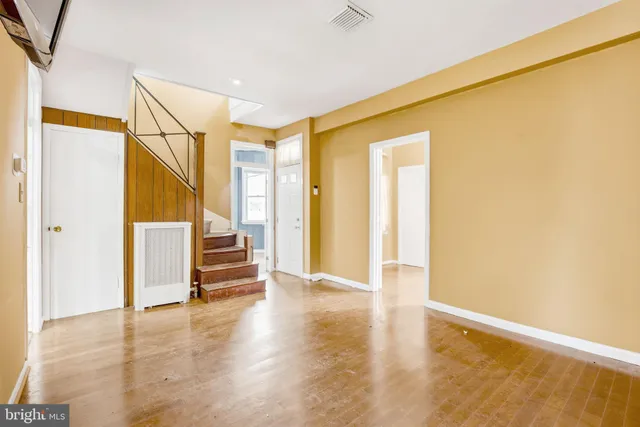 a view of an empty room with stairs and ventilation