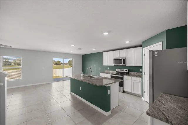 a kitchen with stainless steel appliances granite countertop a refrigerator and a stove top oven