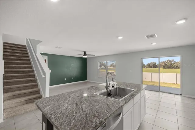 a kitchen with granite countertop a sink and a wooden floor