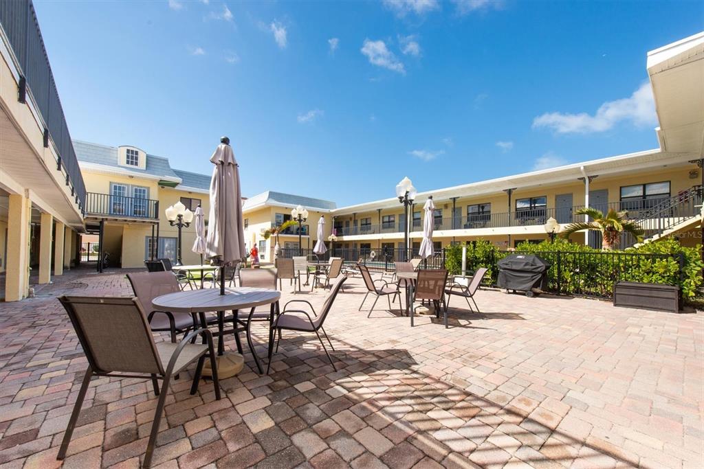 16333 Gulf Boulevard, Unit 201 Redington Beach, FL 33708 - Photo 13 of 39 a view of a patio with a table and chairs and potted plants