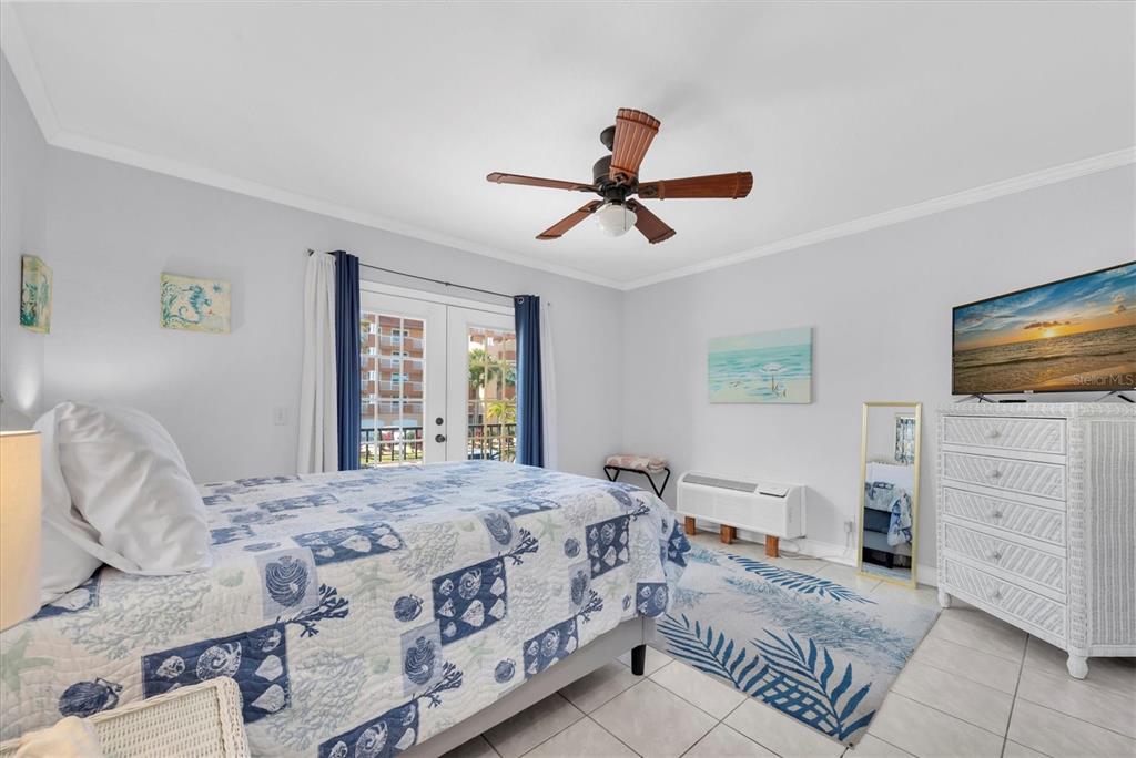16333 Gulf Boulevard, Unit 201 Redington Beach, FL 33708 - Photo 24 of 39 a bedroom with a large bed and a flat screen tv