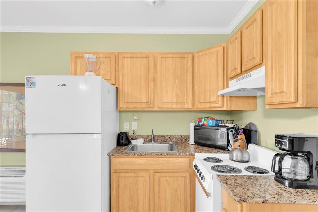 16333 Gulf Boulevard, Unit 201 Redington Beach, FL 33708 - Photo 27 of 39 a kitchen with a refrigerator a stove a sink and cabinets