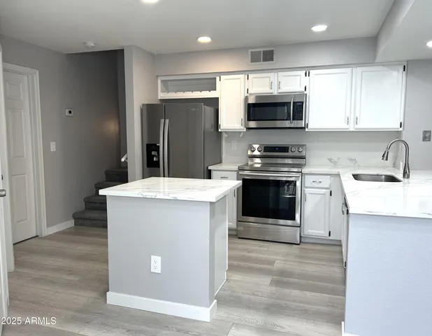 a kitchen with stainless steel appliances a stove a sink and a microwave
