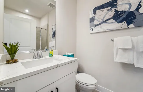 a bathroom with a sink a toilet and mirror
