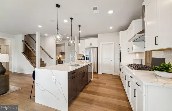 a large kitchen with stainless steel appliances kitchen island granite countertop a large center island attached withe living room