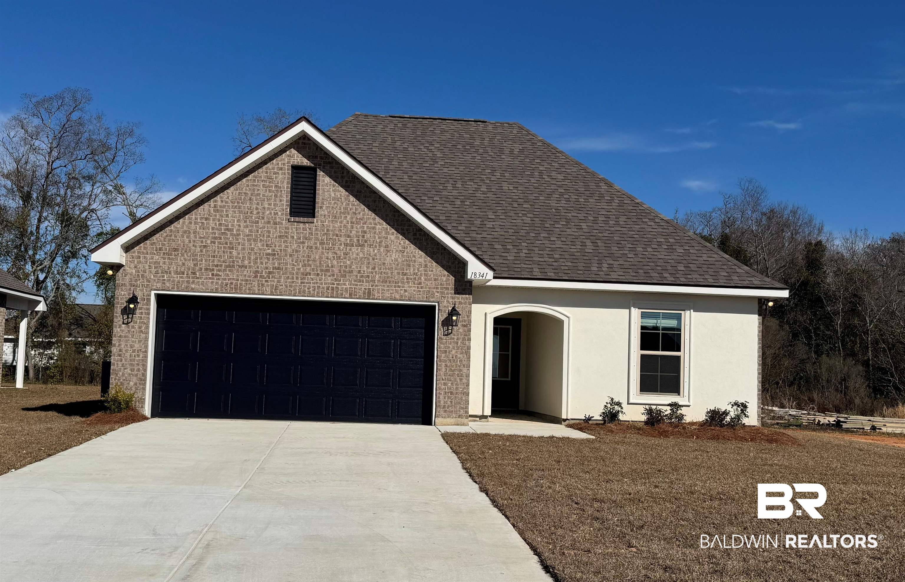 18341 Aden Drive Robertsdale, AL 36567 - Photo 1 of 3 Traditional-style house with concrete driveway, an attached garage, brick siding, roof with shingles, and a front lawn