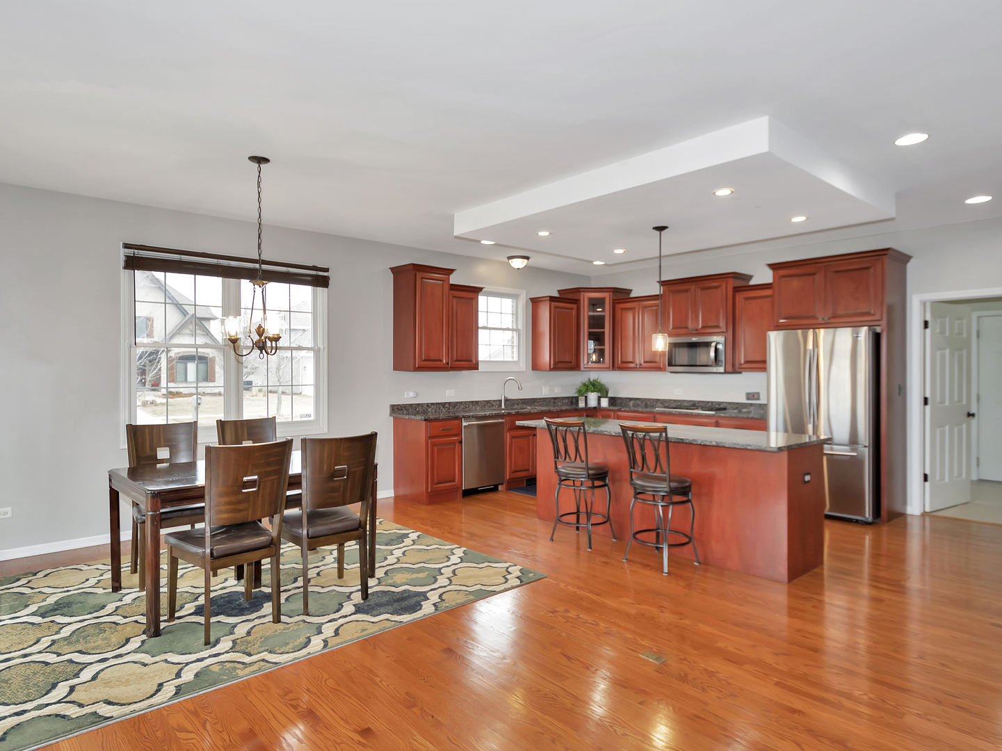 23928 Roberts Street Manhattan, IL 60442 - Photo 18 of 36 a living room with stainless steel appliances kitchen island granite countertop furniture and a kitchen view