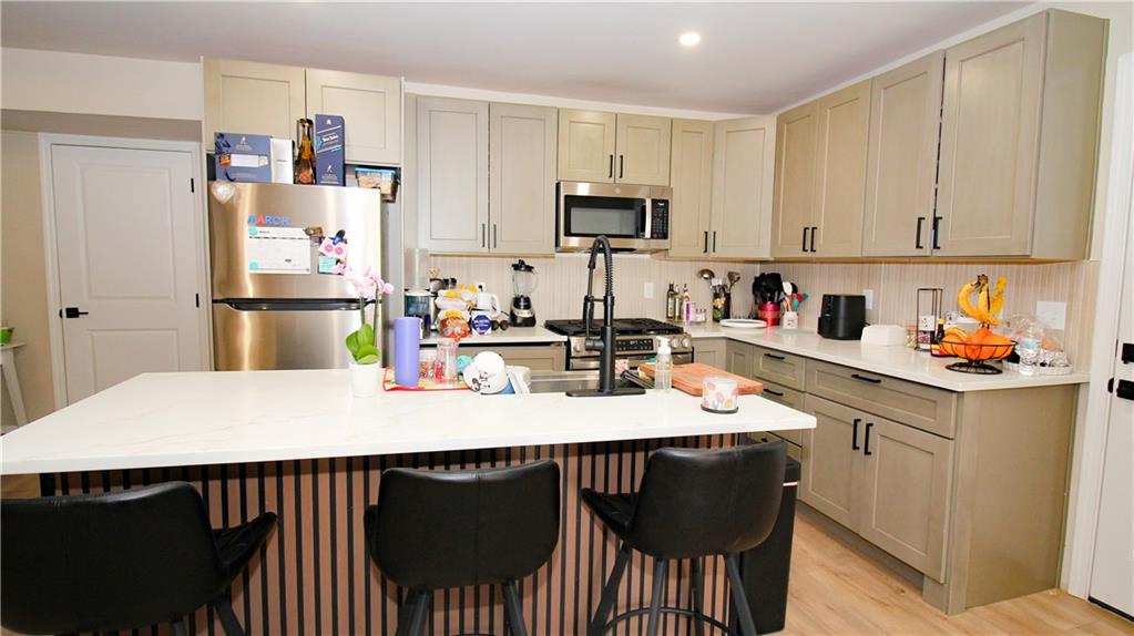 5207 White Boulevard Southwest Mableton, GA 30126 - Photo 14 of 30 a kitchen with stainless steel appliances a dining table chairs refrigerator and sink