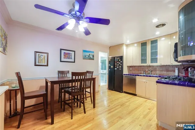 a kitchen with stainless steel appliances granite countertop a dining table and chairs with wooden floor