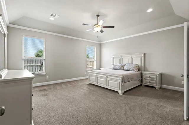 a spacious bedroom with a bed and a chandelier