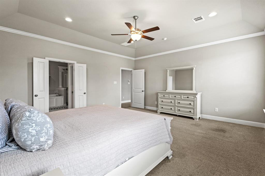 3406 Woodford Drive Mansfield, TX 76084 - Photo 19 of 29 a spacious bedroom with a bed and a chandelier