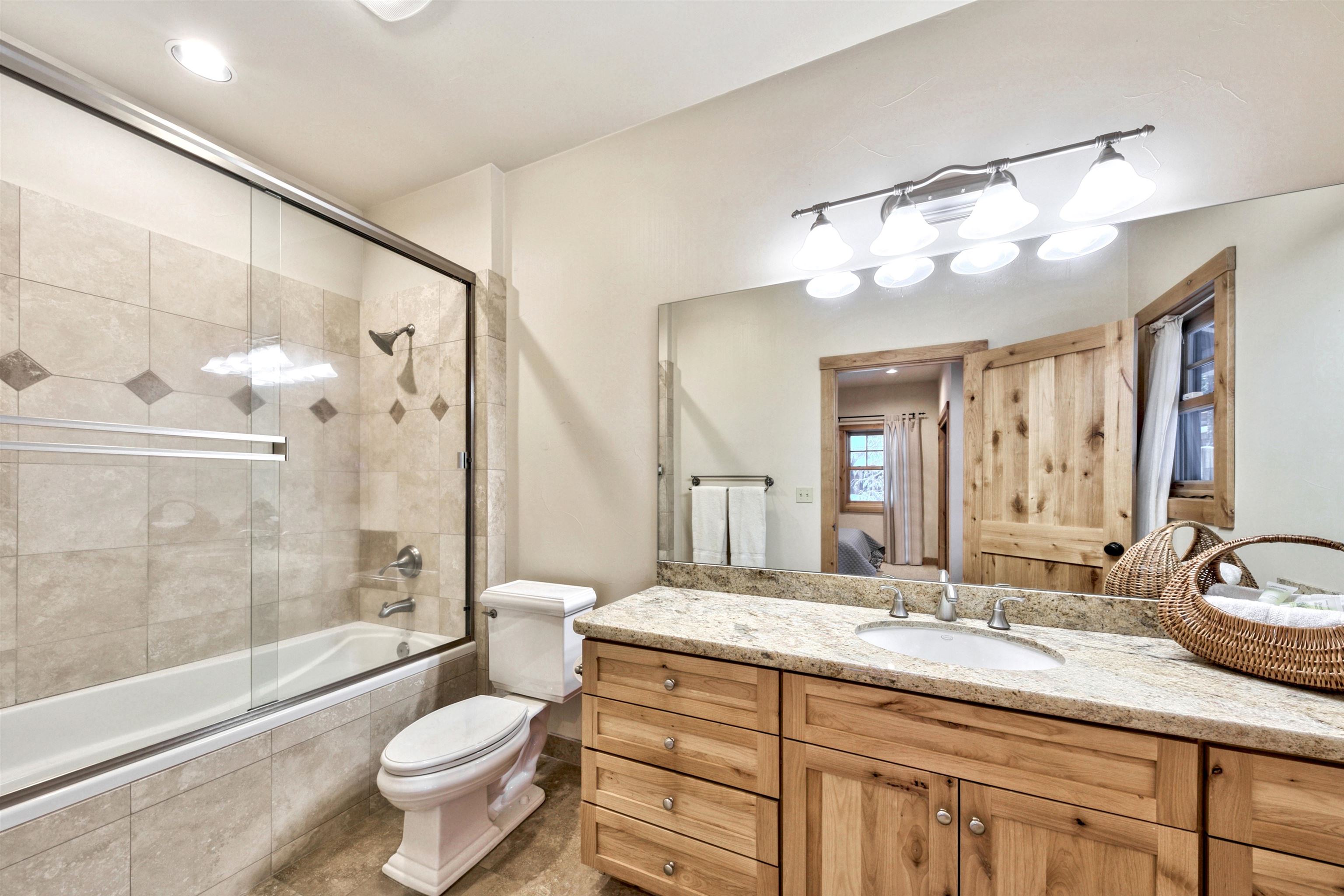 11262 Comstock Drive Truckee, CA 96161 - Photo 15 of 21 a bathroom with a granite countertop sink vanity mirror bathtub shower and a toilet