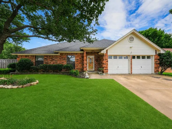 a view of a house with a yard potted plants and large tree