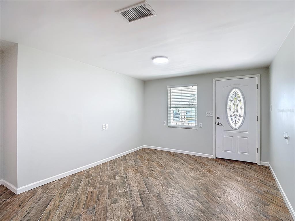13607 Frances Avenue Hudson, FL 34667 - Photo 12 of 76 an empty room with wooden floor and window