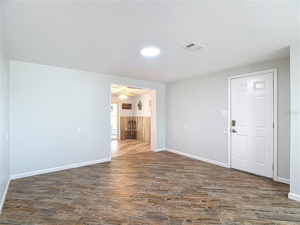 13607 Frances Avenue Hudson, FL 34667 - Photo 14 of 76 a view of an empty room with wooden floor and a window
