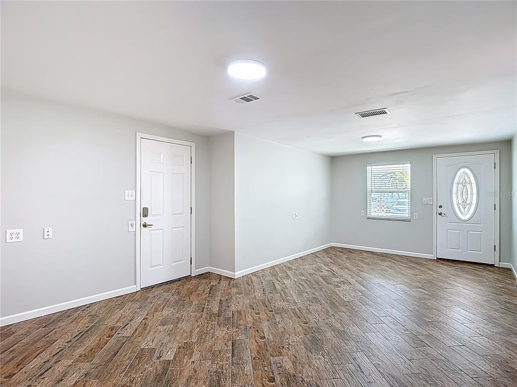 13607 Frances Avenue Hudson, FL 34667 - Photo 15 of 76 a view of an empty room with wooden floor and window