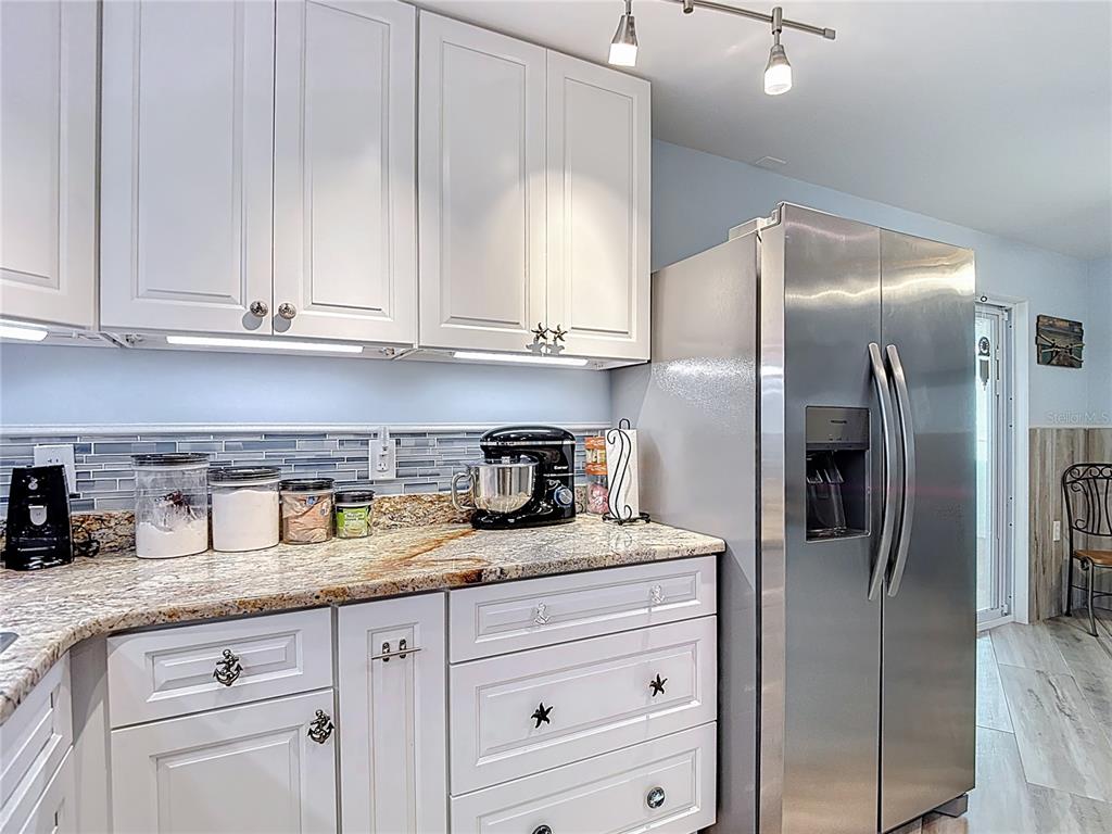 13607 Frances Avenue Hudson, FL 34667 - Photo 24 of 76 a kitchen with stainless steel appliances granite countertop a refrigerator a sink and white cabinets