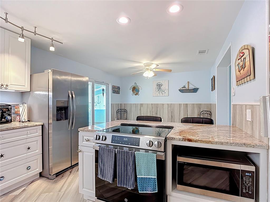 13607 Frances Avenue Hudson, FL 34667 - Photo 27 of 76 a kitchen with stainless steel appliances granite countertop a stove and a refrigerator