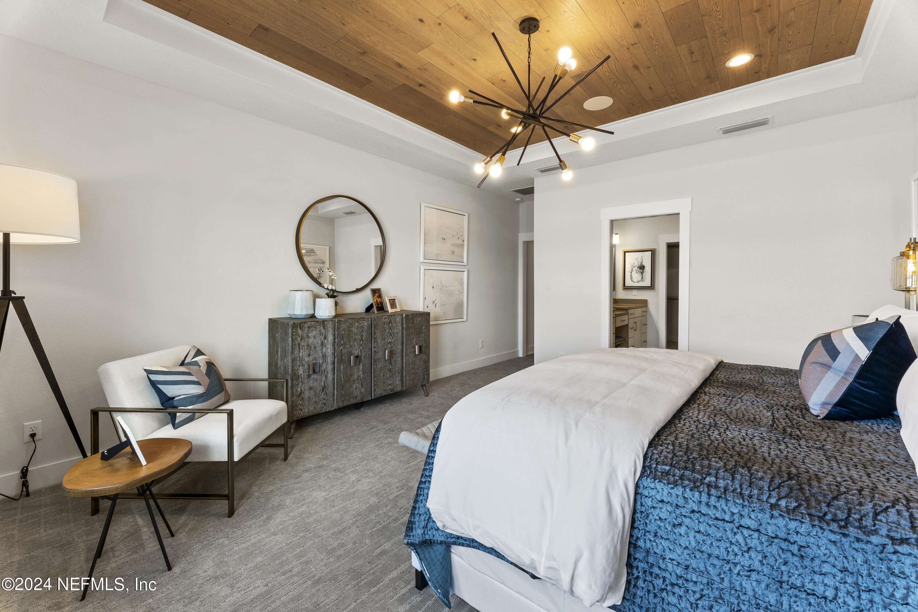 34 Natureland Circle St. Augustine, FL 32092 - Photo 16 of 26 a bedroom with a bed a chair and a chandelier