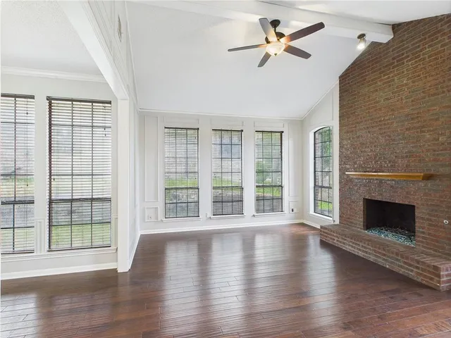 wooden floor fireplace and windows in an empty room