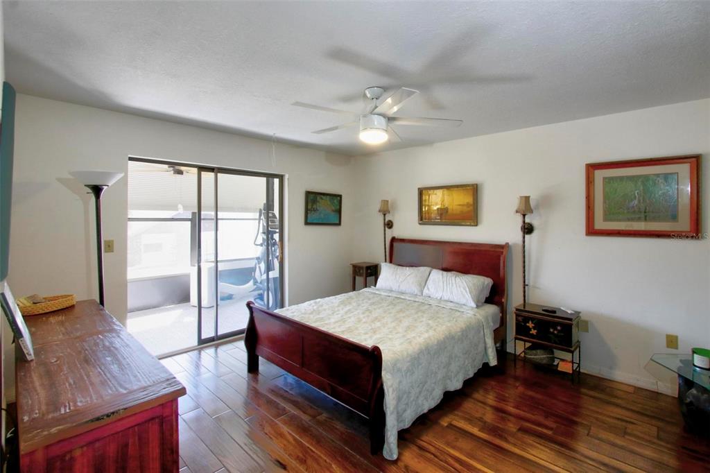 6502 River Run Boulevard, Unit 6502 Weeki Wachee, FL 34607 - Photo 24 of 47 a large bedroom with a bed and wooden floor