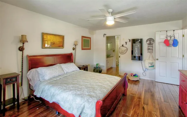 a bedroom with a bed and a table with wooden floor