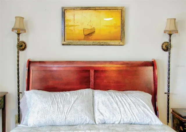 a bedroom with a bed and painting on the wall
