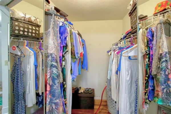 a view of walk in closet with clothes