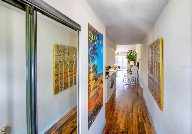 a view of a hallway with wooden floor and a furniture