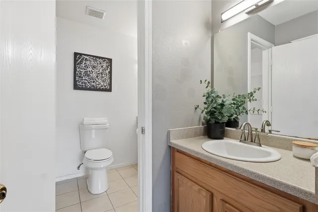 a bathroom with a granite countertop sink and a toilet