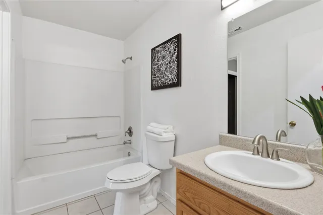 a bathroom with a granite countertop toilet a sink and a mirror