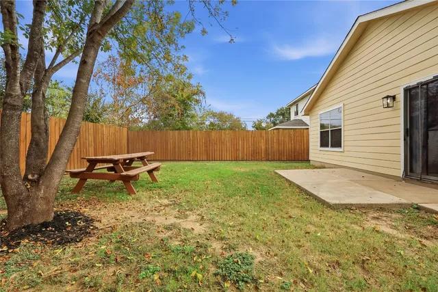 a backyard of a house with table and chairs