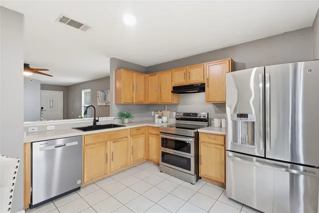a kitchen with white cabinets stainless steel appliances and a window