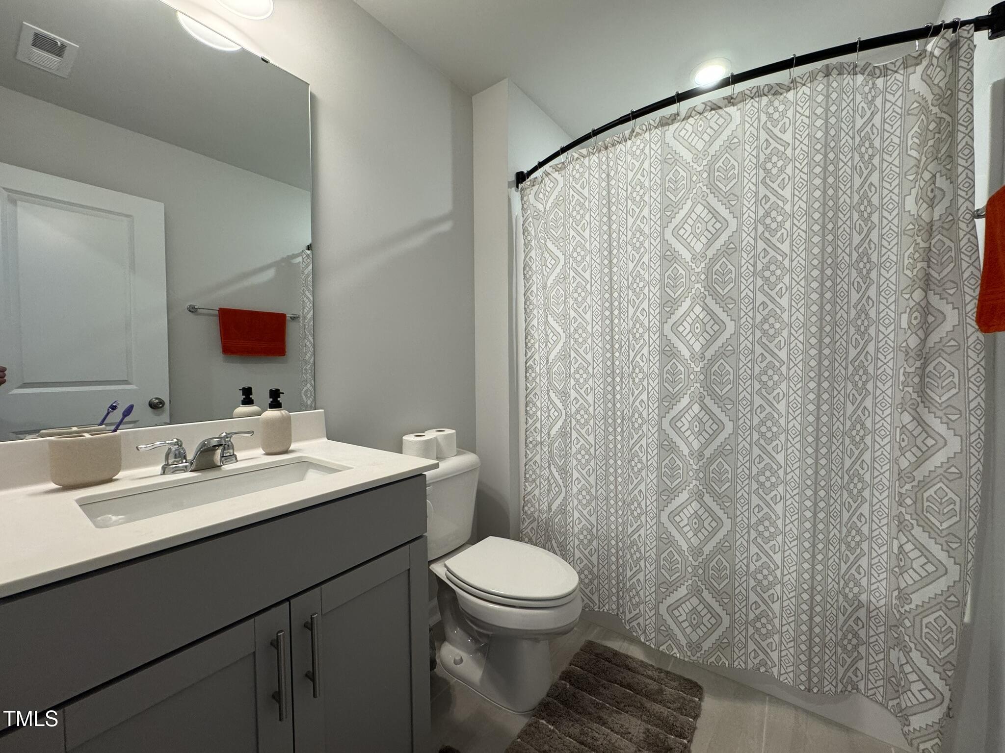 1106 Crossvine Trail Durham, NC 27703 - Photo 21 of 35 a bathroom with a toilet a sink and a mirror