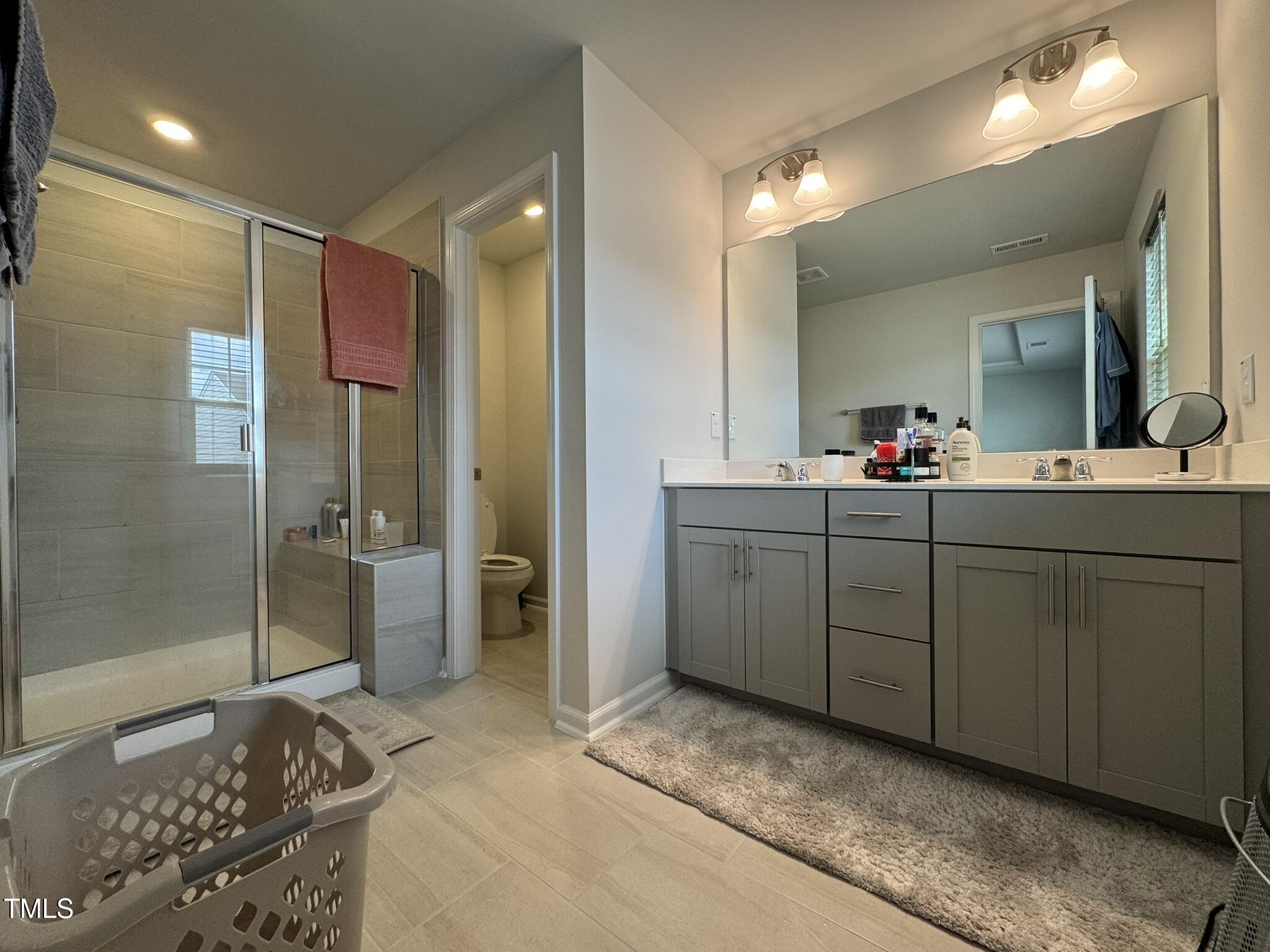 1106 Crossvine Trail Durham, NC 27703 - Photo 27 of 35 a bathroom with a double vanity sink mirror and shower