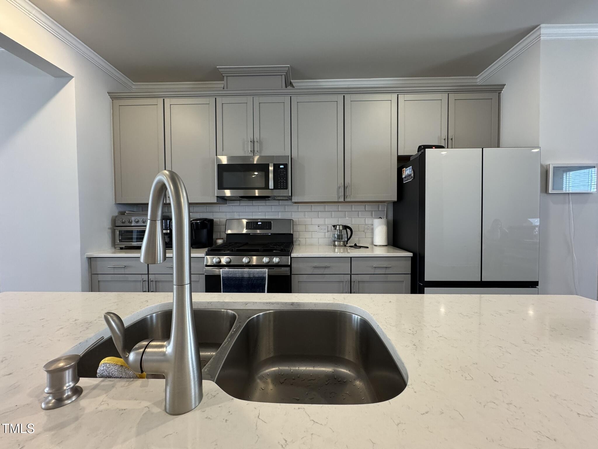 1106 Crossvine Trail Durham, NC 27703 - Photo 9 of 35 a kitchen with stainless steel appliances a refrigerator a sink a stove and cabinets