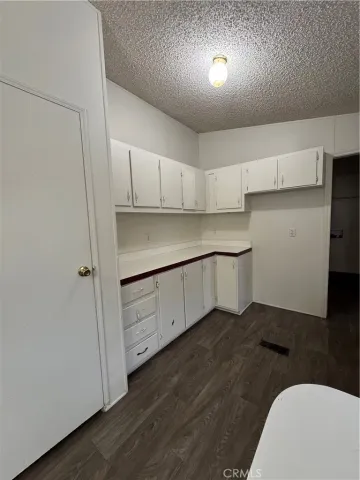 a kitchen with cabinets and wooden floor