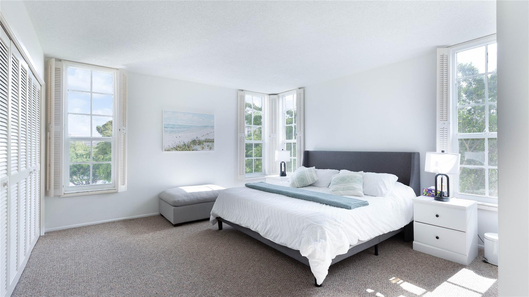 a bedroom with a bed and a large window