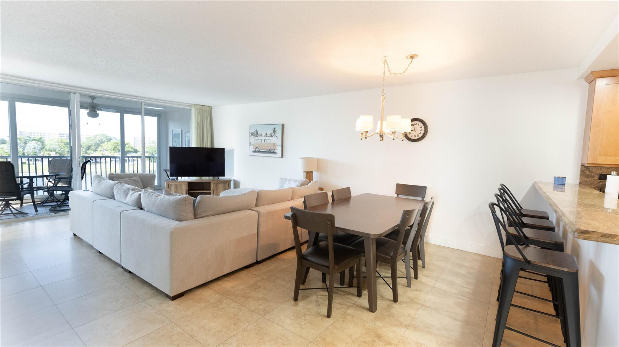 3100 North Course Lane, Unit 510 Pompano Beach, FL 33069 - Photo 13 of 23 a living room with furniture dining table and a flat screen tv