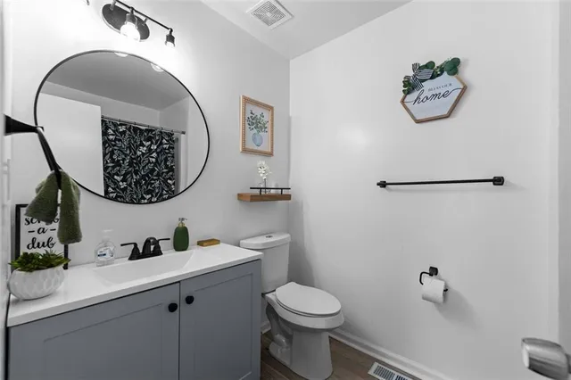 a bathroom with a toilet a sink and mirror