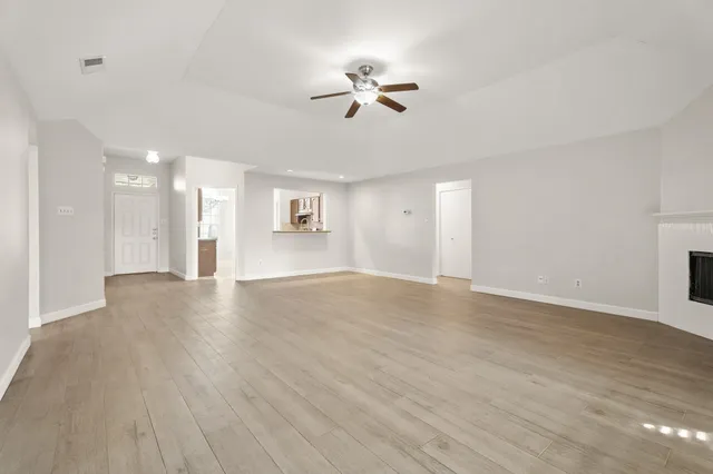a view of a livingroom with a ceiling fan window and wooden floor
