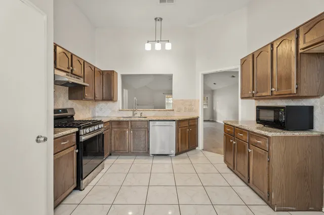 a kitchen with a stove sink and cabinets